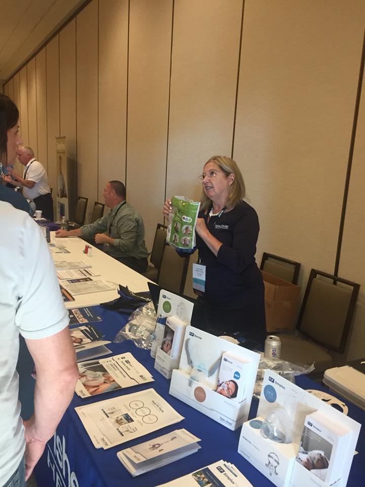 Woman talking to visitors at Wisconsin Sleep Society conference.